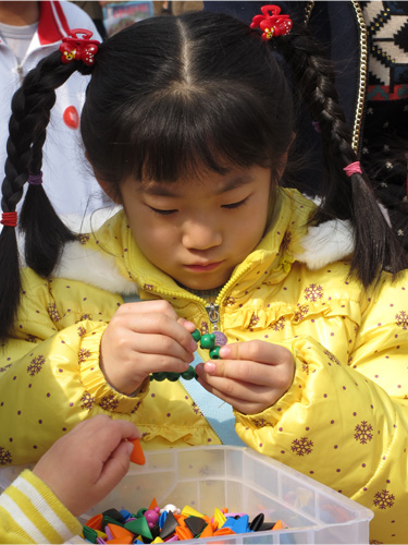 这小姑娘的打扮，阳光灿烂啊，瞧她那专注劲。